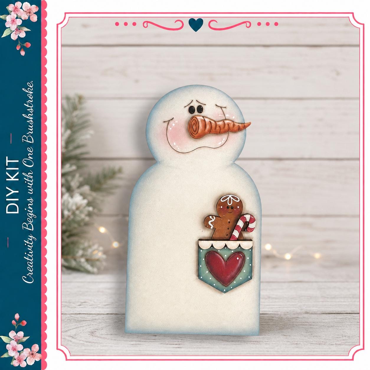 A snowman figure with a gingerbread man figure inside its pocket, set against a wooden background with a small Christmas tree and twinkling lights.