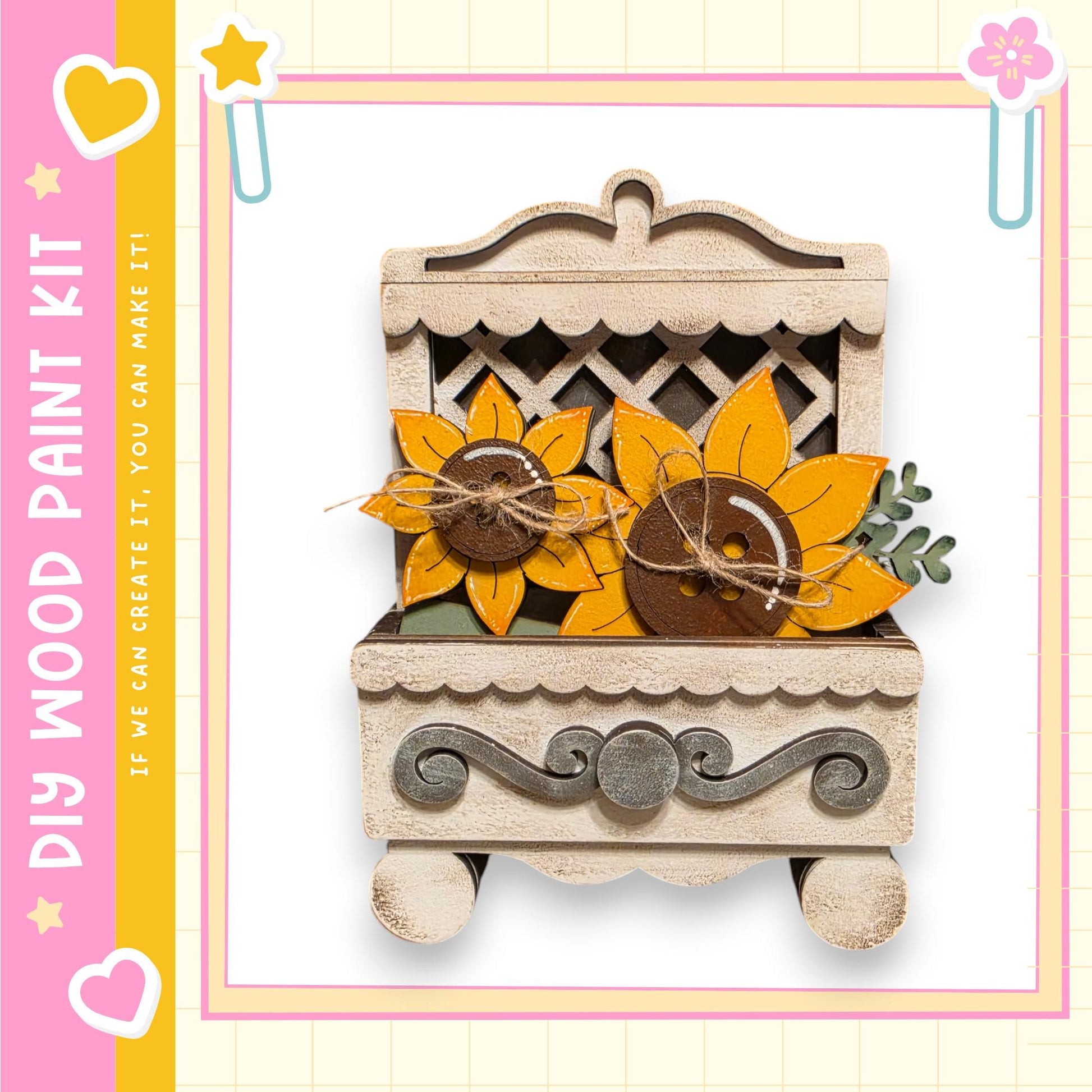 a wooden paint kit with a decorative design, including a carved wooden box with a lid and two painted sunflowers.