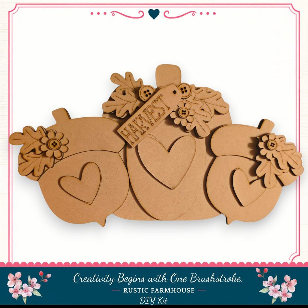 A wooden pumpkin decoration with hearts and leaves, featuring the word "Harvest" on it. The pumpkin is part of a larger wooden decoration set, and the image is described as a DIY kit from a rustic farmhouse.