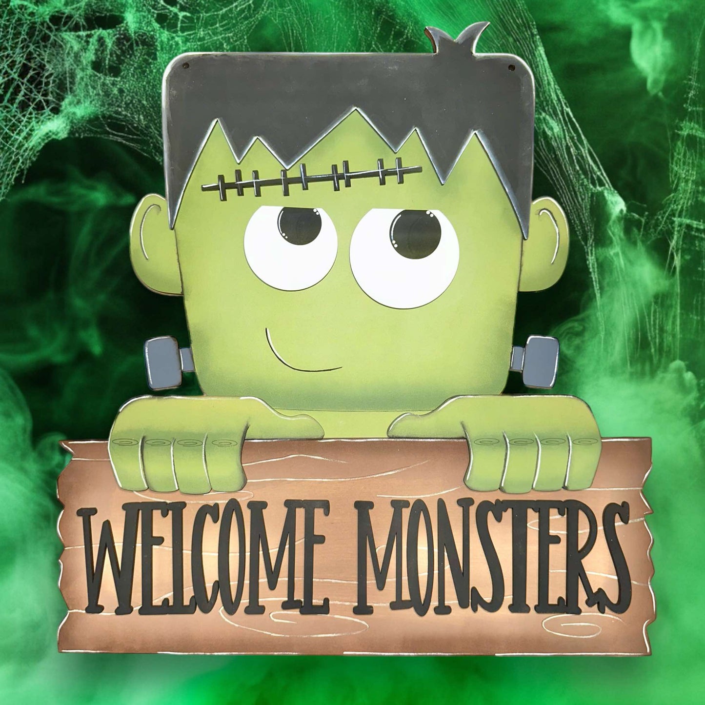 a green monster holding a sign that says welcome monsters