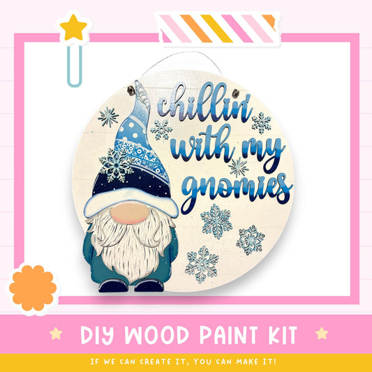 a DIY wood paint kit for creating a wooden sign with a gnome design. The kit includes a gnome illustration and the text "chillin' with my gnomes" written on the sign.