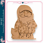 A wooden cutout of Santa Claus holding a teddy bear and a sack of presents, with a heart-shaped decoration above the figure.