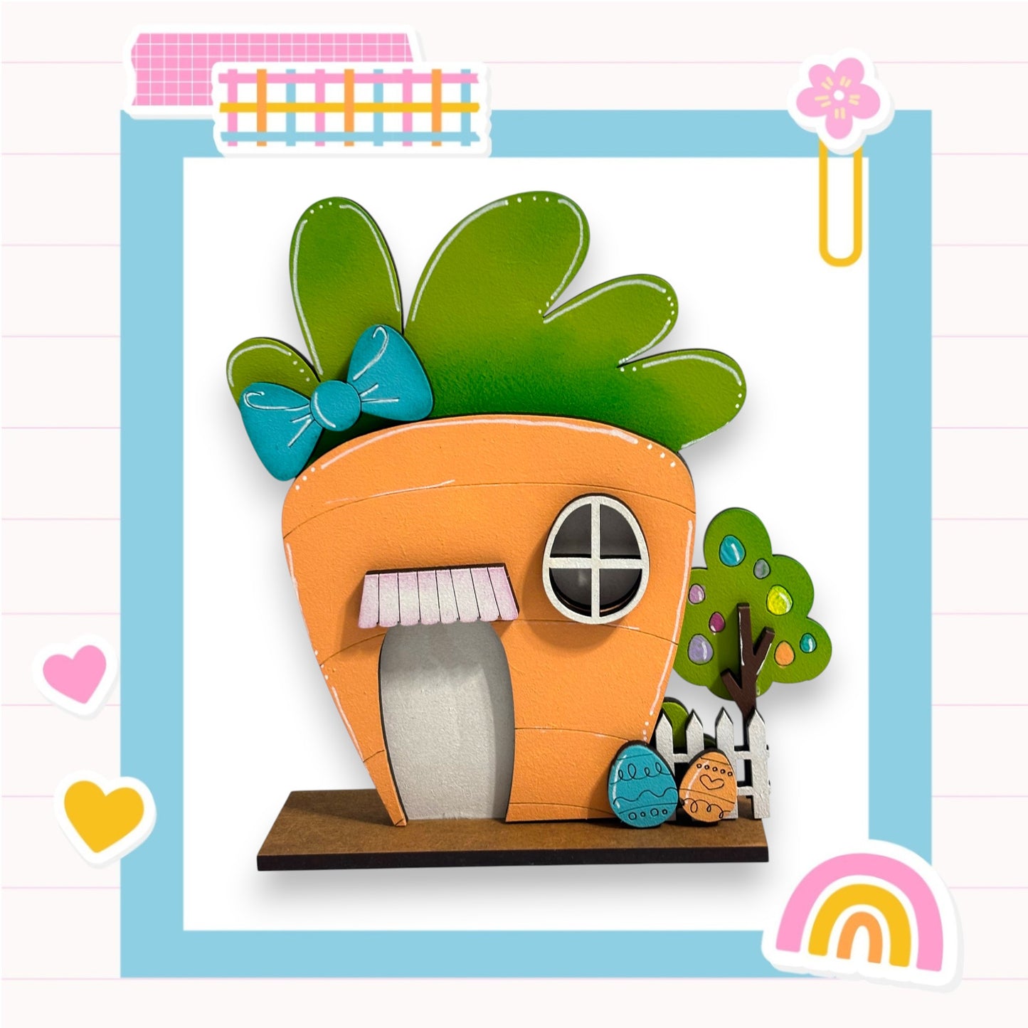 A whimsical, handcrafted wooden house in the shape of a carrot, adorned with a bow and surrounded by a tree and other decorative elements, set against a colorful background.