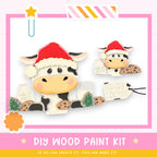 a DIY wood paint kit for creating a Christmas-themed cow decoration. The kit includes a cow-shaped cookie, a cookie-shaped tag, and a cookie-shaped tag. The cow is wearing a Santa hat and holding a cookie. The kit is designed to allow users to create their own Christmas-themed cow decorations.