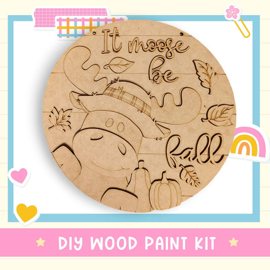 A wooden sign with the text "It moose be fall" carved into it, surrounded by various fall-themed elements such as leaves and a pumpkin.