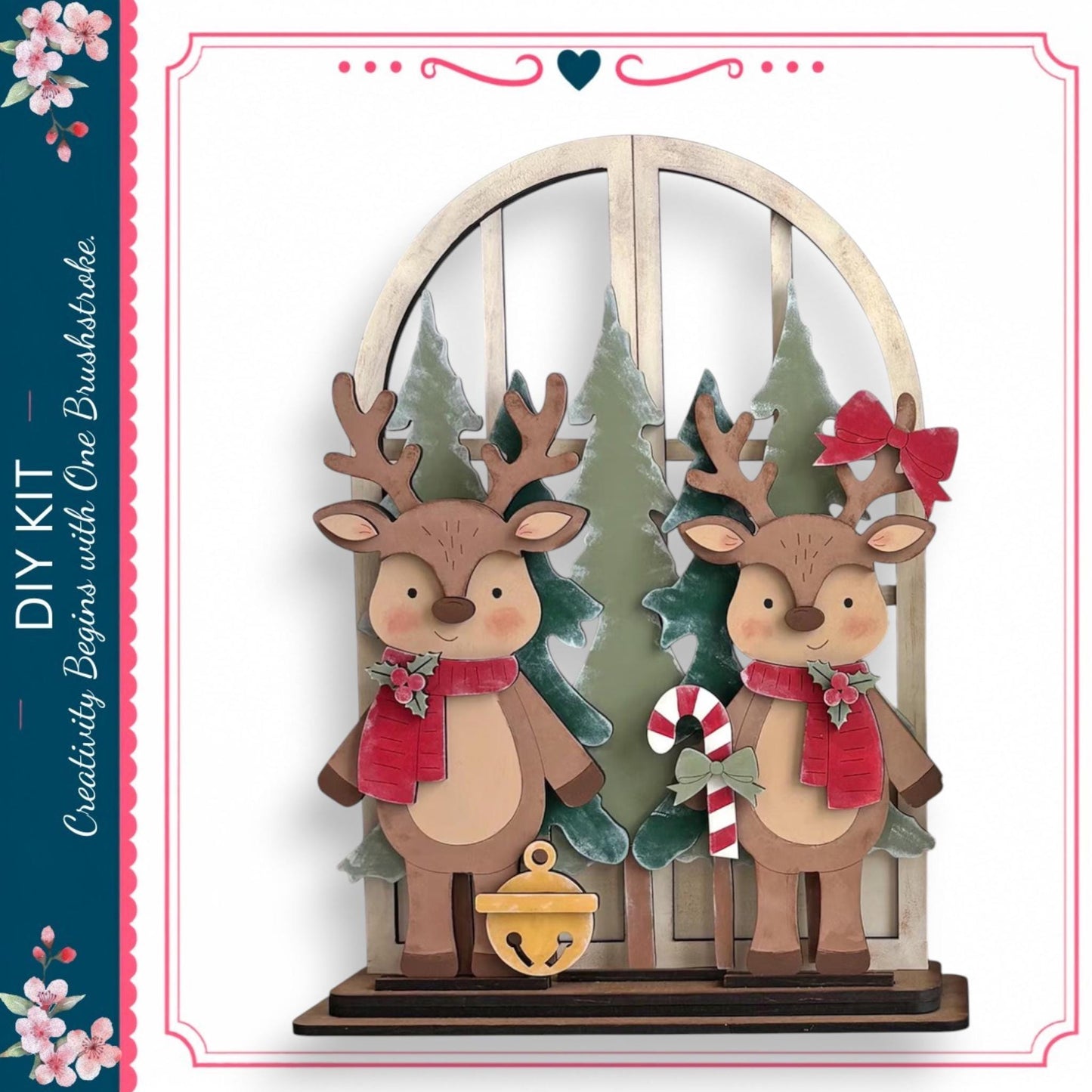 A wooden deer figurine stands in front of a Christmas tree, with two other deer figurines on either side. The deer are wearing red scarves and have antlers. The scene is set against a backdrop of a snowy landscape with pine trees.