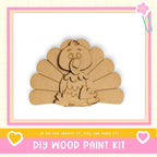 a DIY wood paint kit, with a wooden turkey figure as the main focus. The kit appears to be made of cardboard and is designed for children to create their own wooden designs.