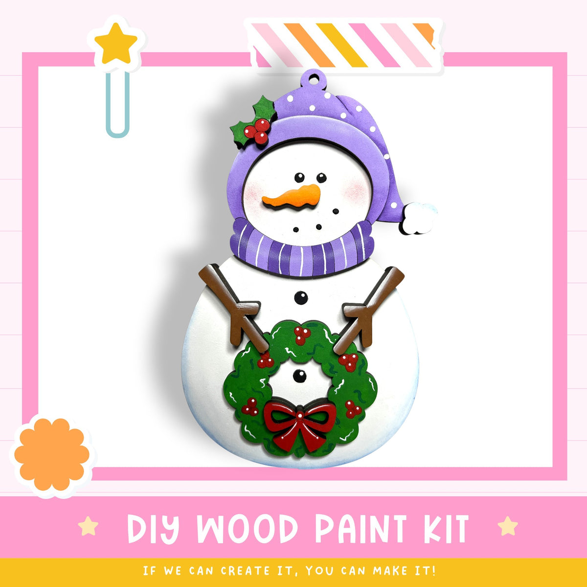 A snowman wearing a purple hat and scarf, with a wreath on its chest, is depicted in the image. The text below the snowman reads "DIY WOOD PAINT KIT" and "IF WE CAN CREATE IT, YOU CAN MAKE IT!"