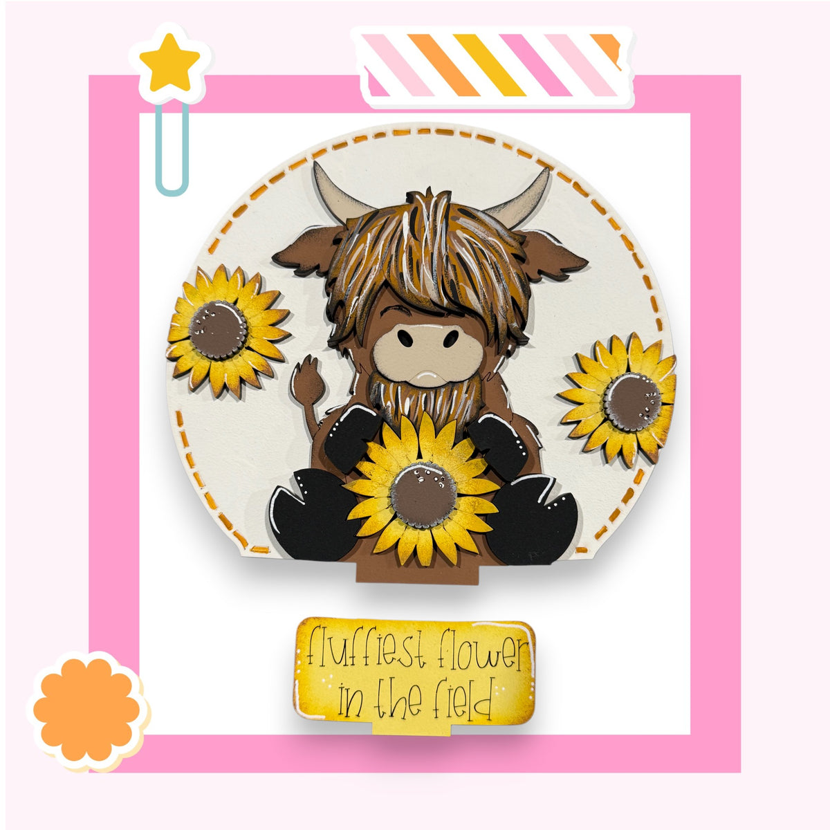 A cartoon cow holding a bunch of yellow sunflowers, with a pink and white striped border and a yellow star decoration.
