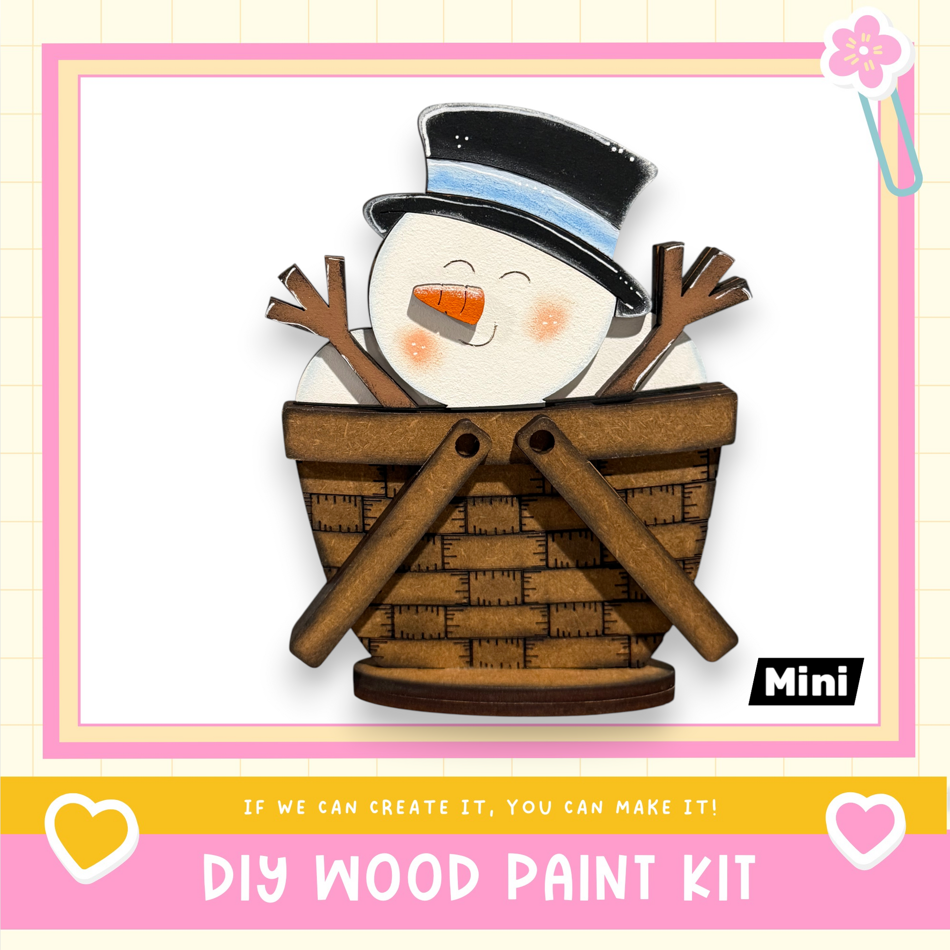 A wooden snowman figure sitting in a basket, with a caption that reads "If we can create it, you can make it!" and a DIY wood paint kit label.