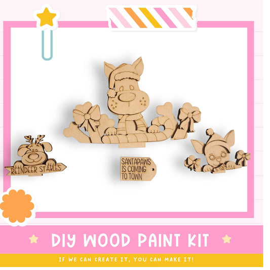 The image is a colorful advertisement for a DIY wood paint kit, featuring a cartoon Santa Claus and other festive decorations.