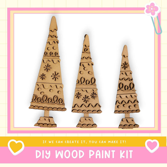 three wooden Christmas trees with intricate designs, displayed in a frame.