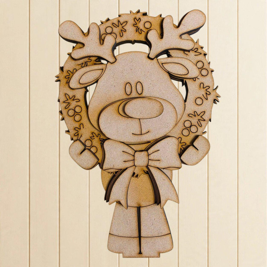 A wooden cutout of a reindeer wearing a wreath and a bow, set against a light-colored background.