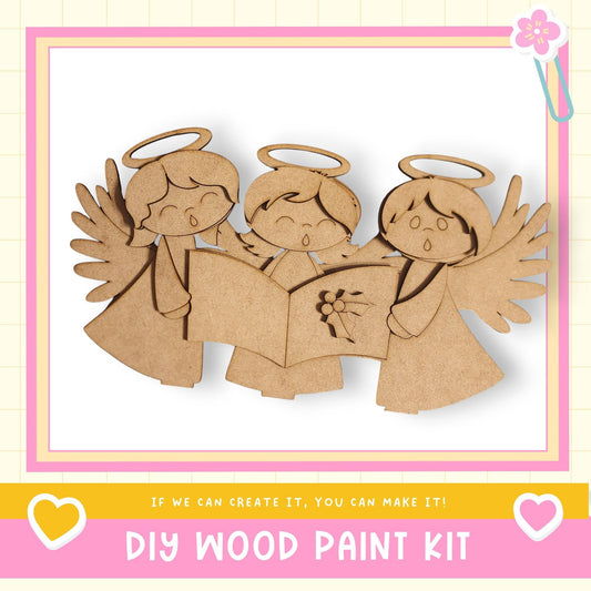 The image is a DIY wood paint kit featuring three wooden angels with wings, each holding a book. The text below the image encourages creativity and says, "If we can create it, you can make it!"