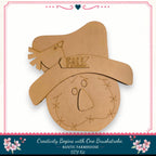 a wooden scarecrow with a hat and the word "FALL" written on it, along with a decorative border.