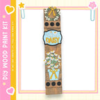 a wooden sign with a floral design and the text "Daisy" on it, surrounded by decorative elements such as a wreath and a heart.