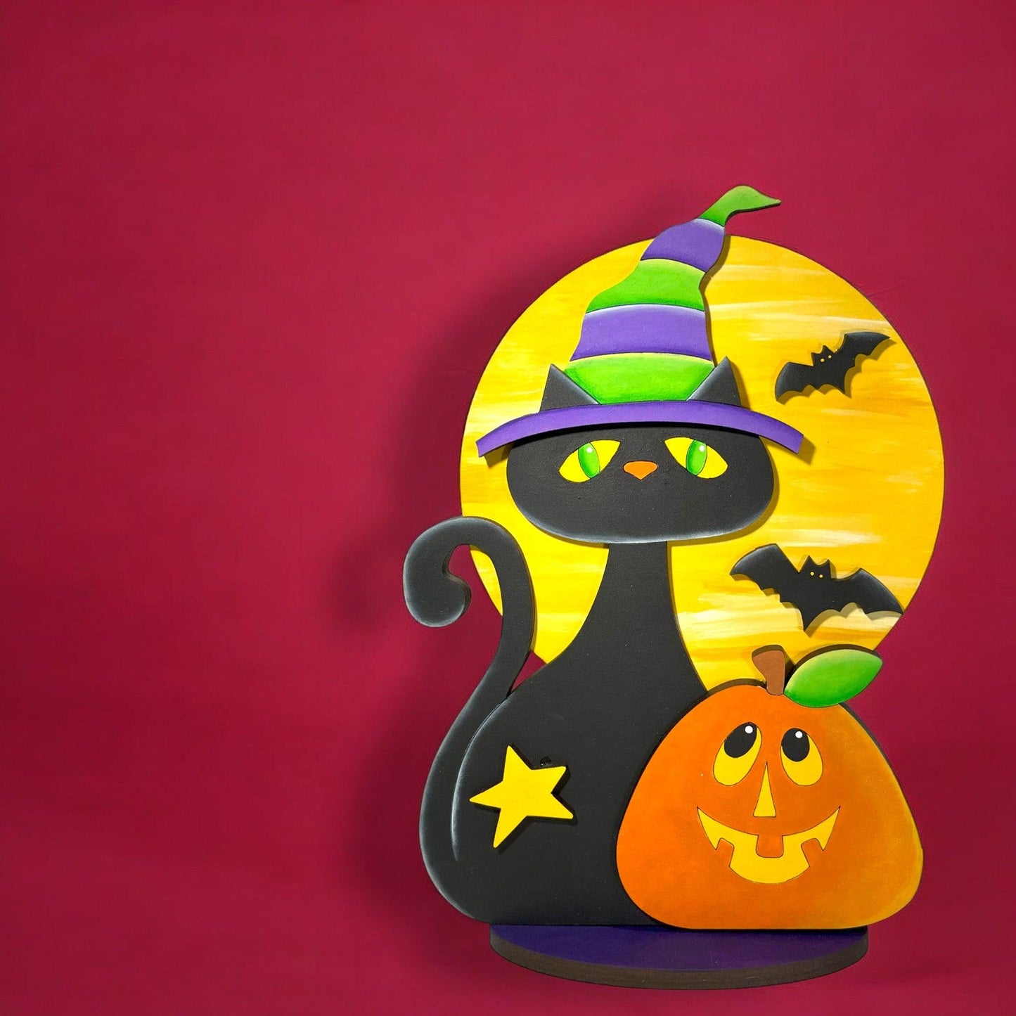 a black cat wearing a witches hat with a pumpkin