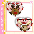 two heart-shaped ornaments, one with a reindeer and the other with a moose, both wearing Santa hats.
