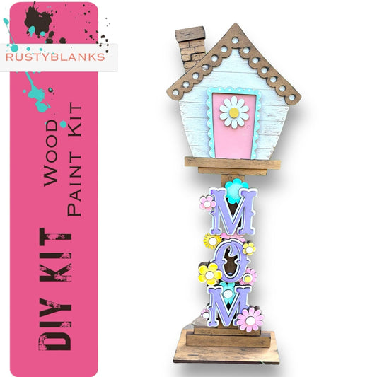 a wooden birdhouse with a pink door and window