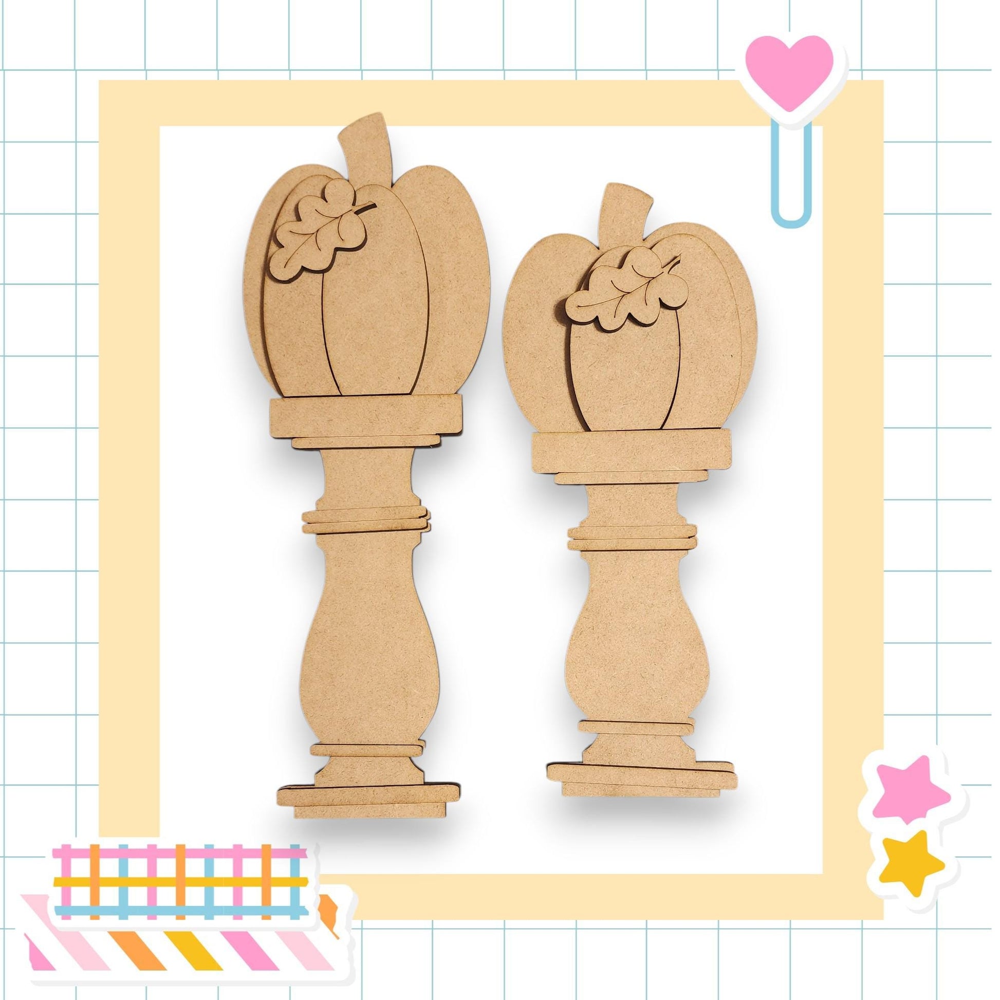 two wooden pumpkin-shaped objects, possibly carved from cardboard or a similar material, set against a grid background with a heart and star decoration.