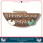 a wooden sign with the text "Welcome to our Patch" and two pumpkins, one white and one green, against a white background.