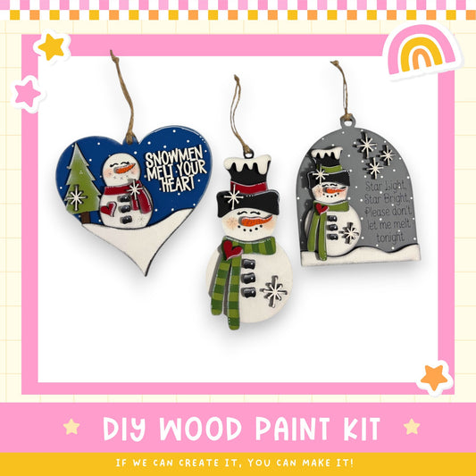 three wooden ornaments hanging on a wall, each with a unique design and color scheme.