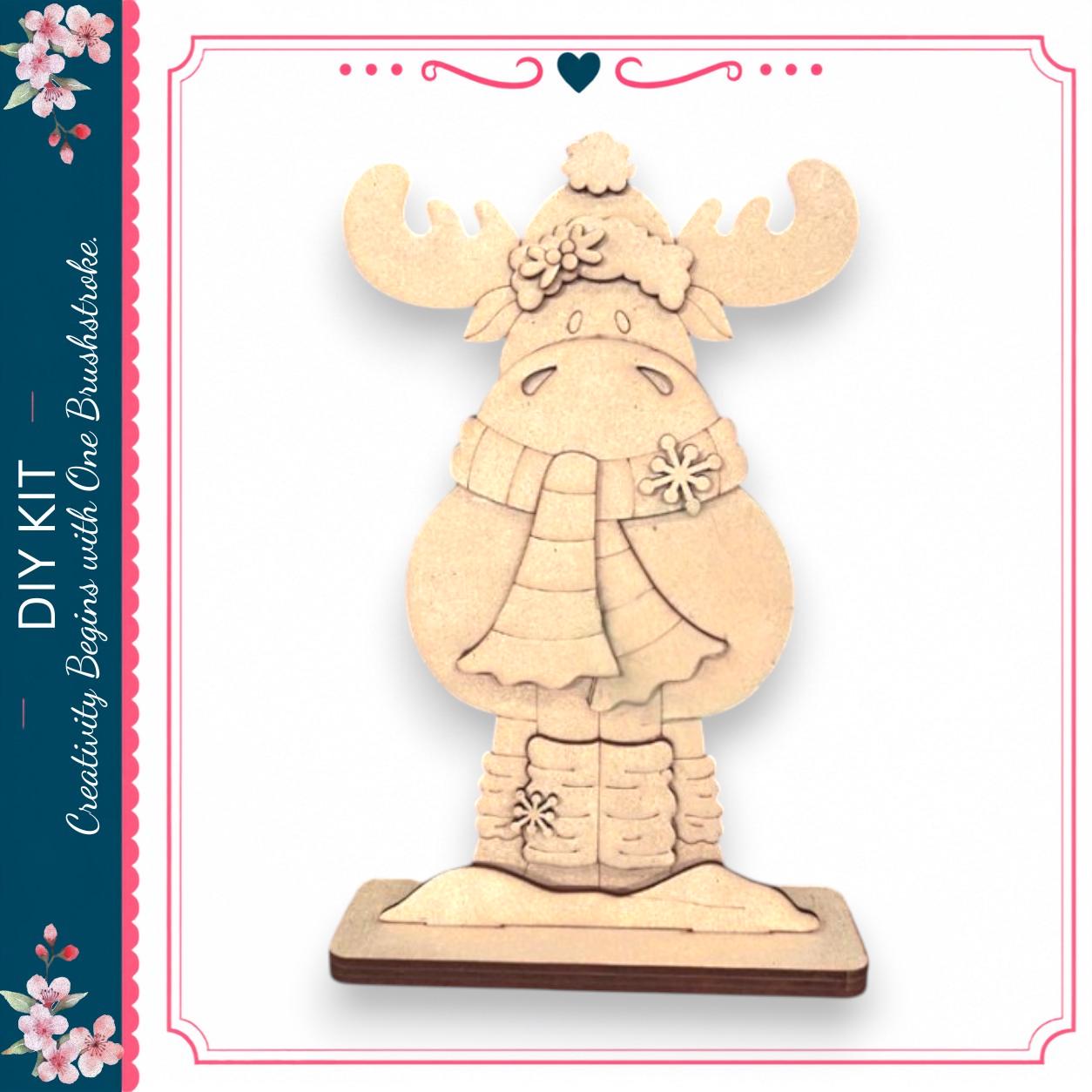 A wooden snowman decoration with antlers and a scarf, sitting on a wooden base.