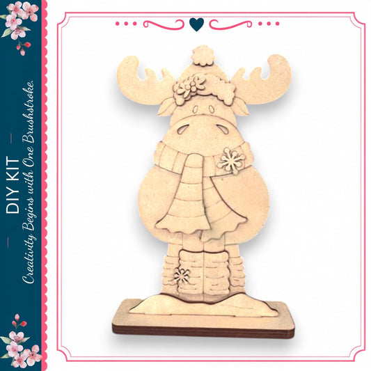 A wooden snowman decoration with antlers and a scarf, sitting on a wooden base.