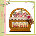 A wooden basket with a lace trim, decorated with a sign that says "Farm Fresh Berries". The basket is filled with strawberries, and there is a rose attached to it. The image is a decorative piece, likely used for display or as a gift.
