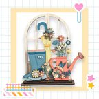 A wooden window sill with a vase of flowers, a pair of blue rain boots, and a pink watering can, all set against a white background with a grid pattern.