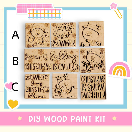 The image is a DIY wood paint kit featuring a collection of wooden snowman and Christmas-themed designs.