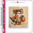 A hand-made fabric with a Halloween-themed ghost character wearing a bow and holding a pumpkin.