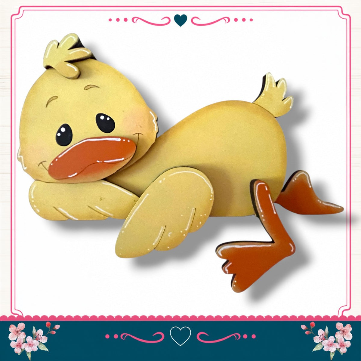 A cheerful yellow duck with orange beak and feet is depicted in a playful pose, surrounded by a decorative border with pink and blue floral elements.