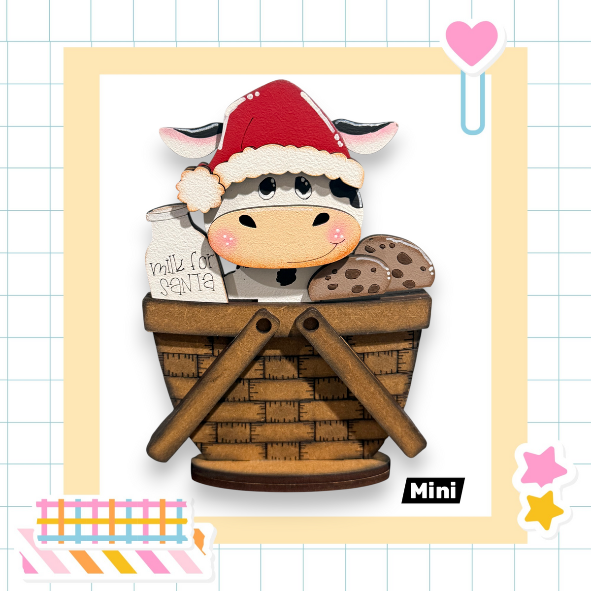 A wooden basket with a cow wearing a Santa hat and holding a milk carton and cookies.