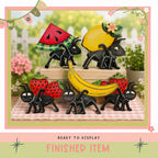 a collection of whimsical, colorful figurines of insects and fruits, including a watermelon, a banana, and strawberries, arranged in a playful and imaginative manner.