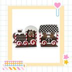 A wooden train made of gingerbread cookies, with a black roof and red and white striped wheels, is displayed against a white background.