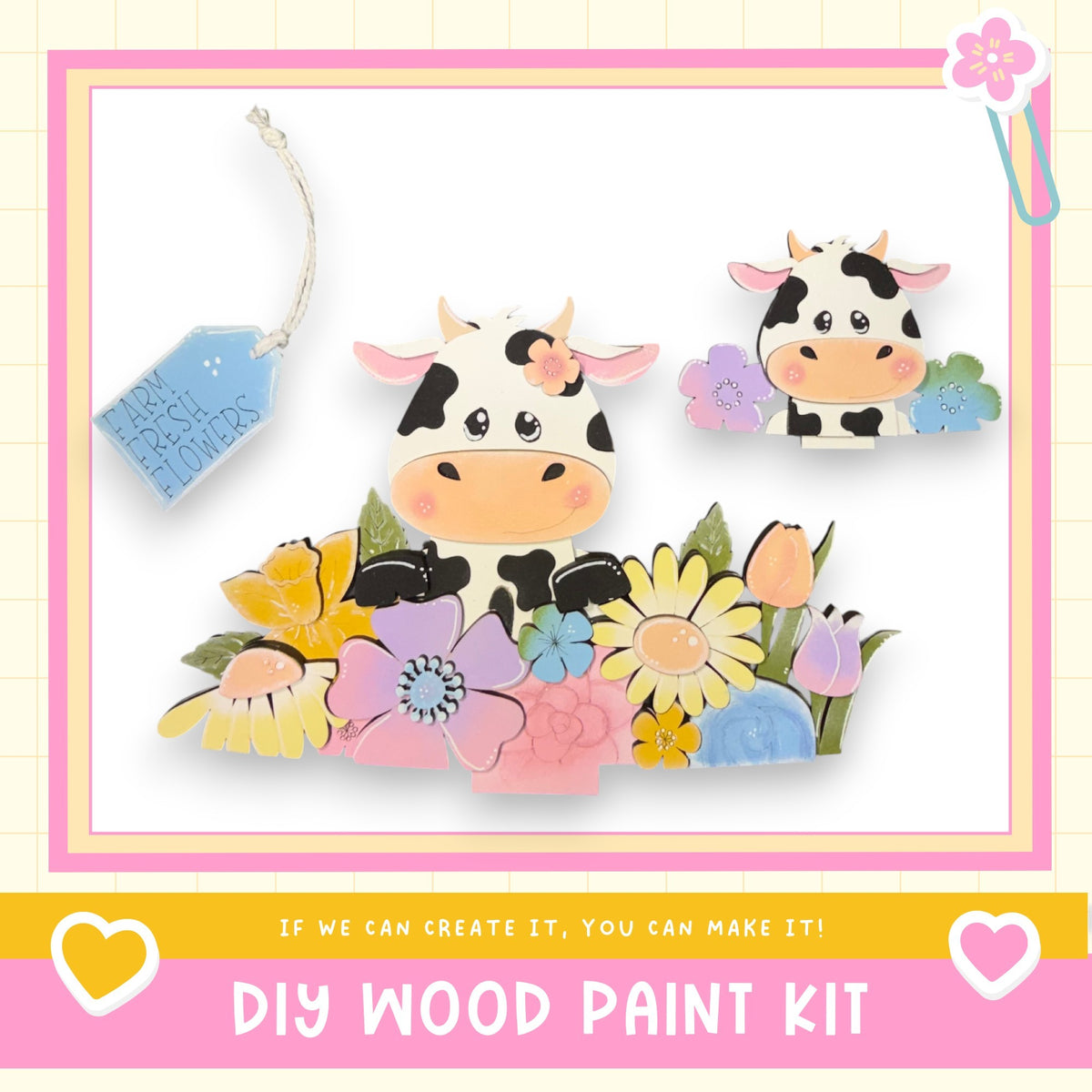 The image is a colorful and whimsical DIY wood paint kit featuring two cow-shaped cutouts surrounded by a variety of flowers and leaves. The kit appears to be designed for children, as indicated by the playful and vibrant nature of the scene.