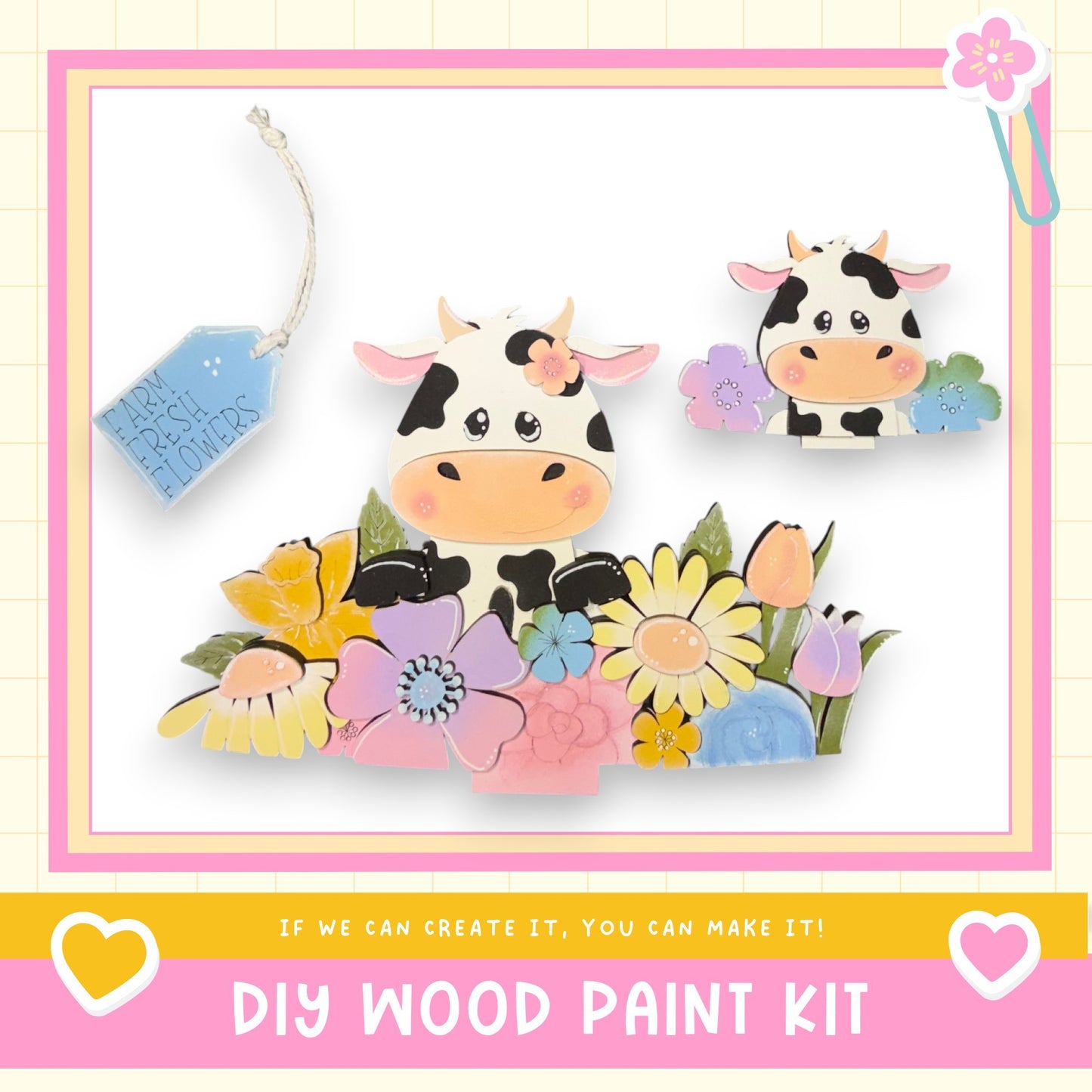 The image is a colorful and whimsical DIY wood paint kit featuring two cow-shaped cutouts surrounded by a variety of flowers and leaves. The kit appears to be designed for children, as indicated by the playful and vibrant nature of the scene.