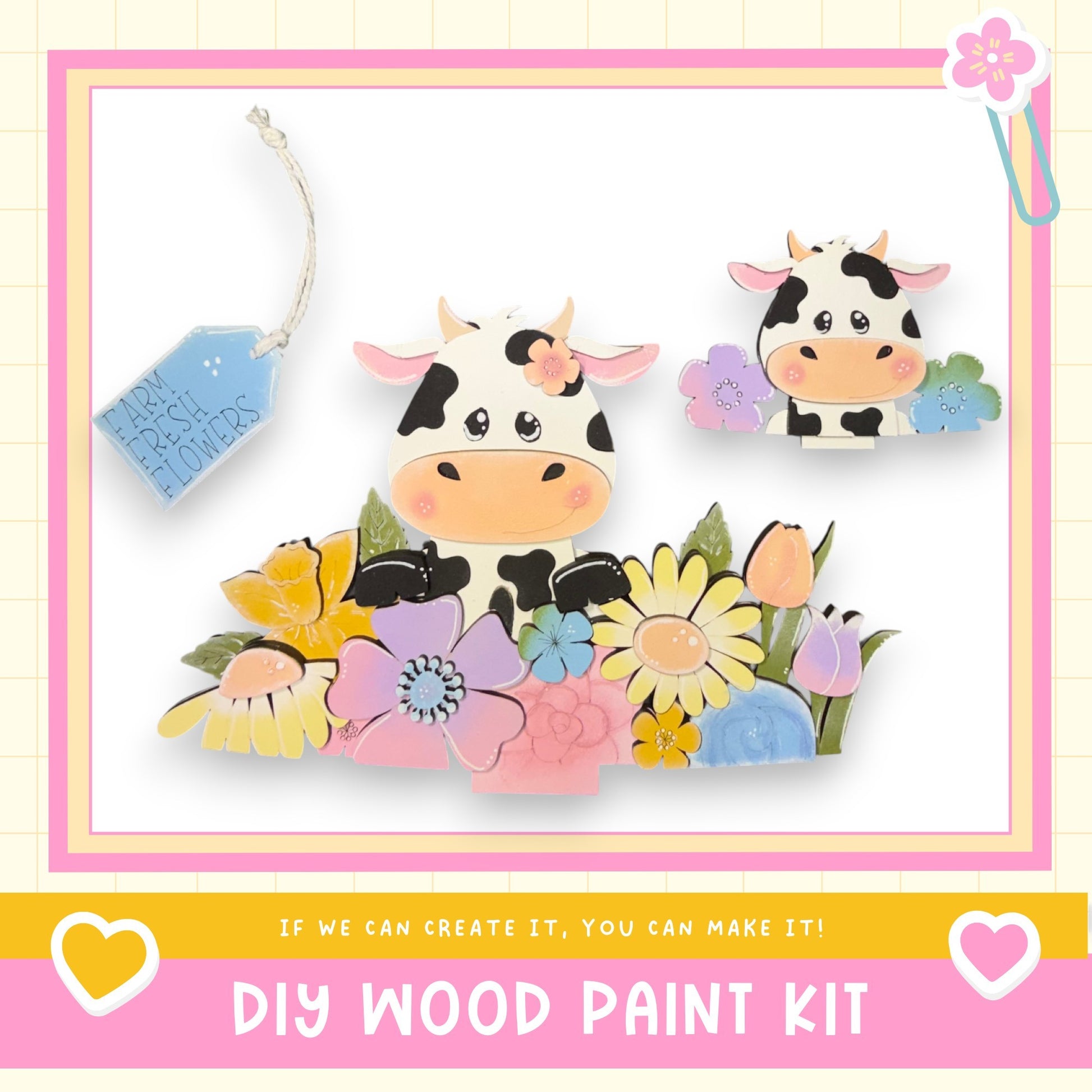 The image is a colorful and whimsical DIY wood paint kit featuring two cow-shaped cutouts surrounded by a variety of flowers and leaves. The kit appears to be designed for children, as indicated by the playful and vibrant nature of the scene.
