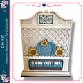 a decorative wooden sign with a lattice pattern, a blue pumpkin, and sunflowers, along with the text "Hello Autumn".