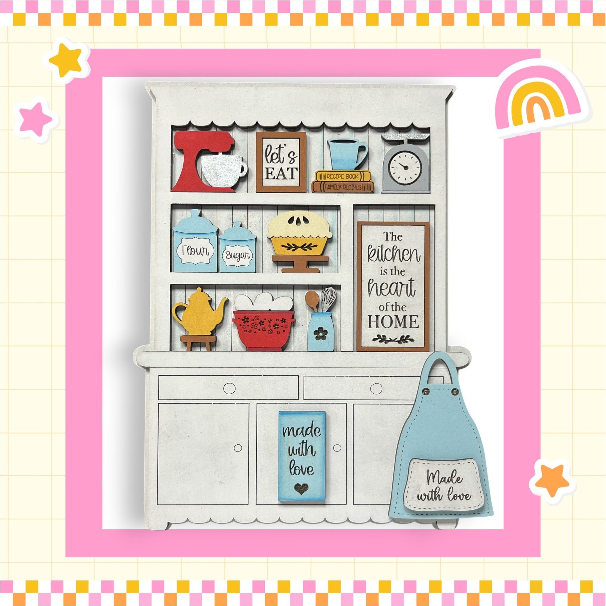 A wooden kitchen cabinet with various kitchen items and a sign that reads "The kitchen is the heart of the home".