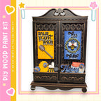 The image is a wooden paint kit featuring a decorative cabinet with various items, including a bee, a honey jar, and a wreath.