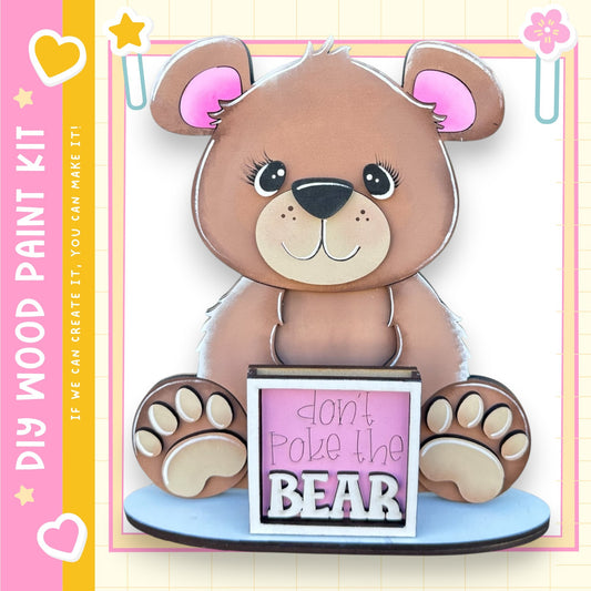 A wooden teddy bear with a sign that says "Don't poke the bear" is displayed in the image.