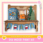 A DIY wood paint kit featuring a moose figure, a fishing sign, and a garland of flags. The kit appears to be made of wood and is designed for creating custom wooden decorations.