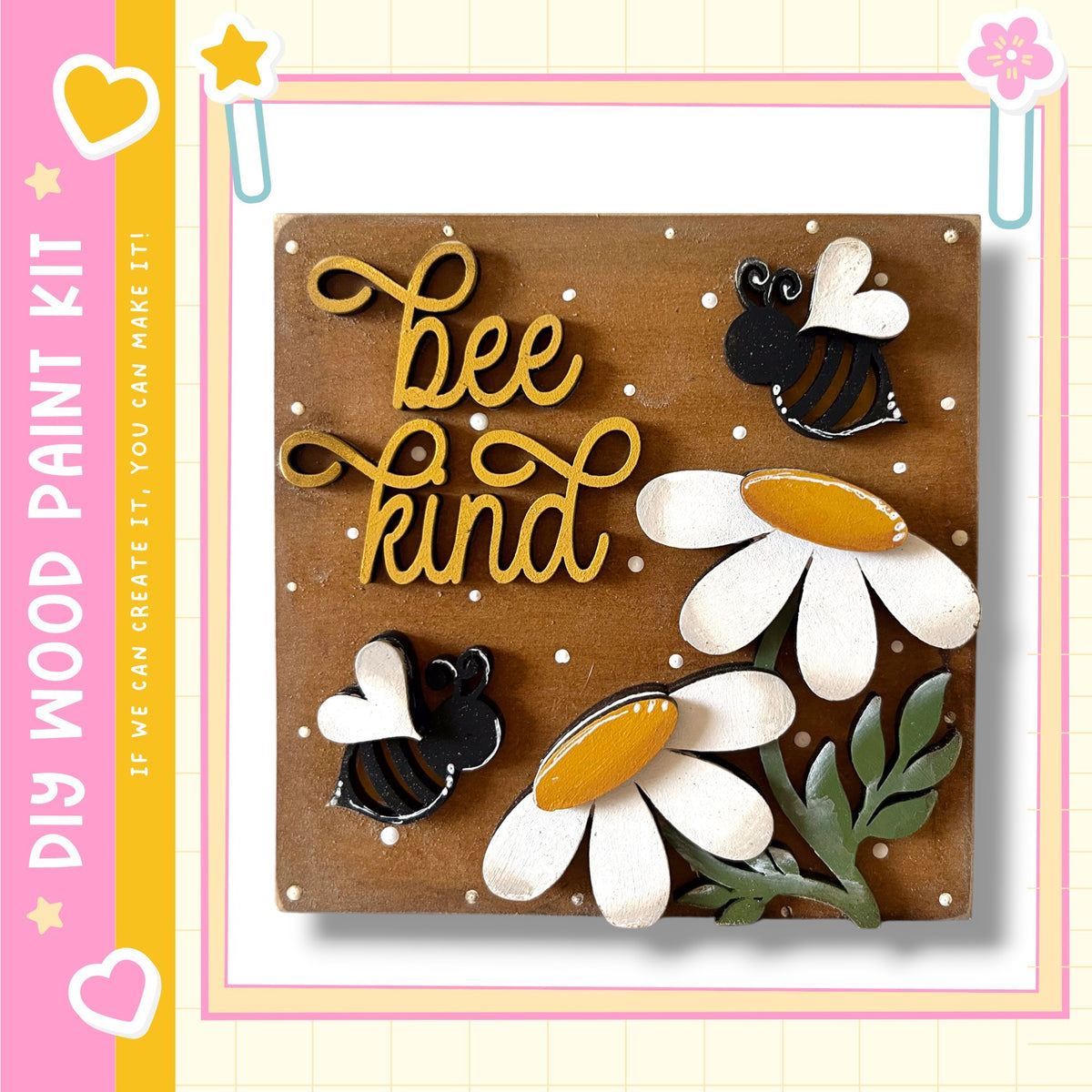 The image is a wooden paint kit featuring a decorative design with a bee and flowers. The kit includes a wooden board with the words "bee kind" written on it, along with bee and flower cutouts. The kit appears to be a creative project for children, as indicated by the "DIY" label.