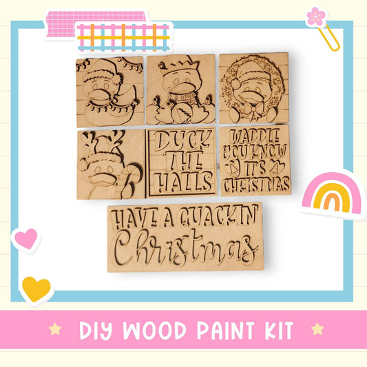 The image is a DIY wood paint kit featuring a collection of wooden stickers with various Christmas-themed designs, including ducks, snowmen, and holiday phrases.