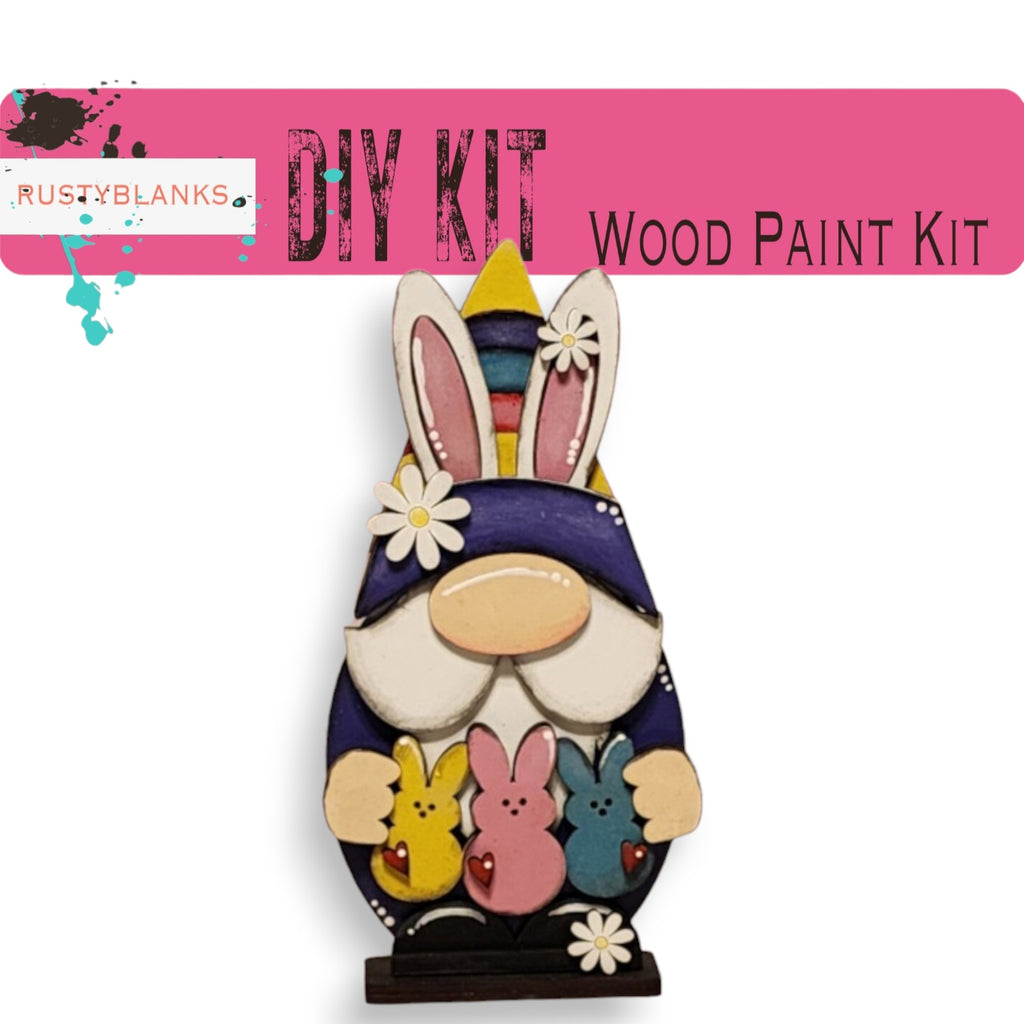 a colorful wooden paint kit with a gnome-like figure holding various small animal figurines, including rabbits and chicks.
