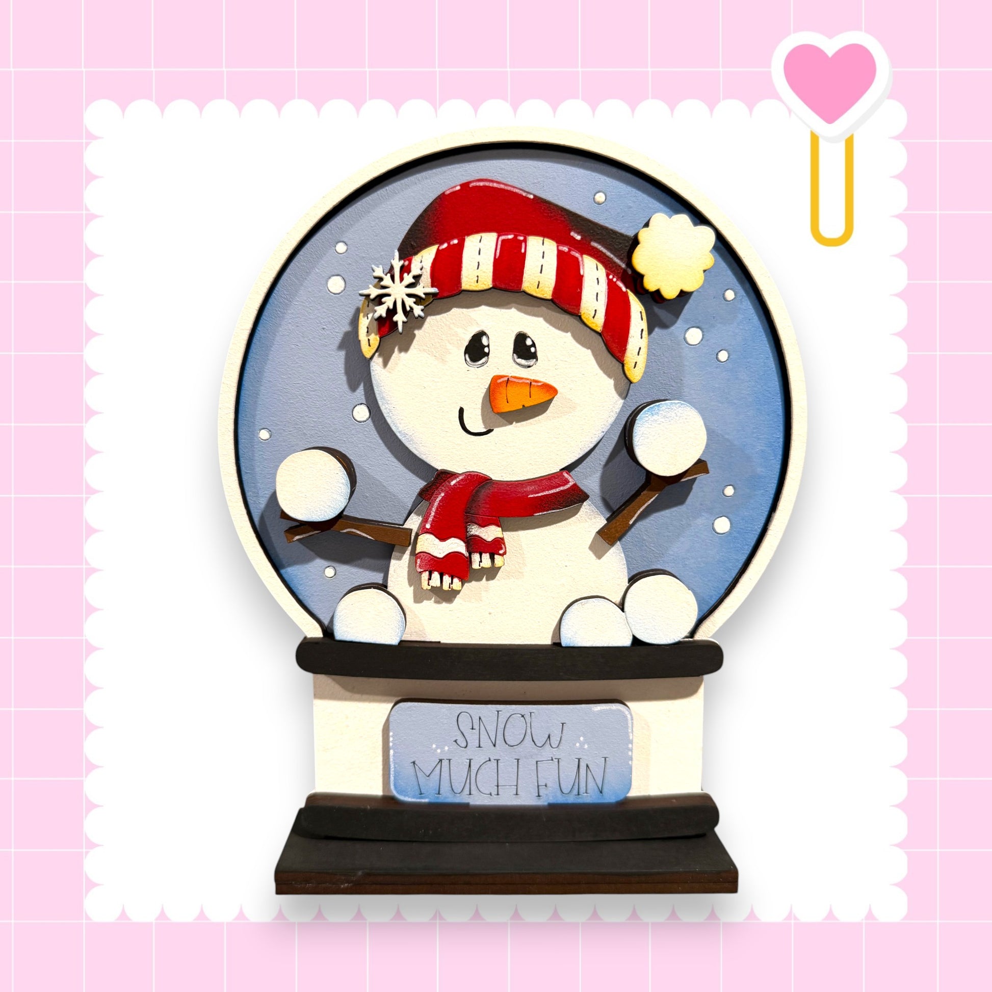 A snowman figurine with a red scarf and hat, sitting inside a snow globe with the words "Snow much fun" written on it.