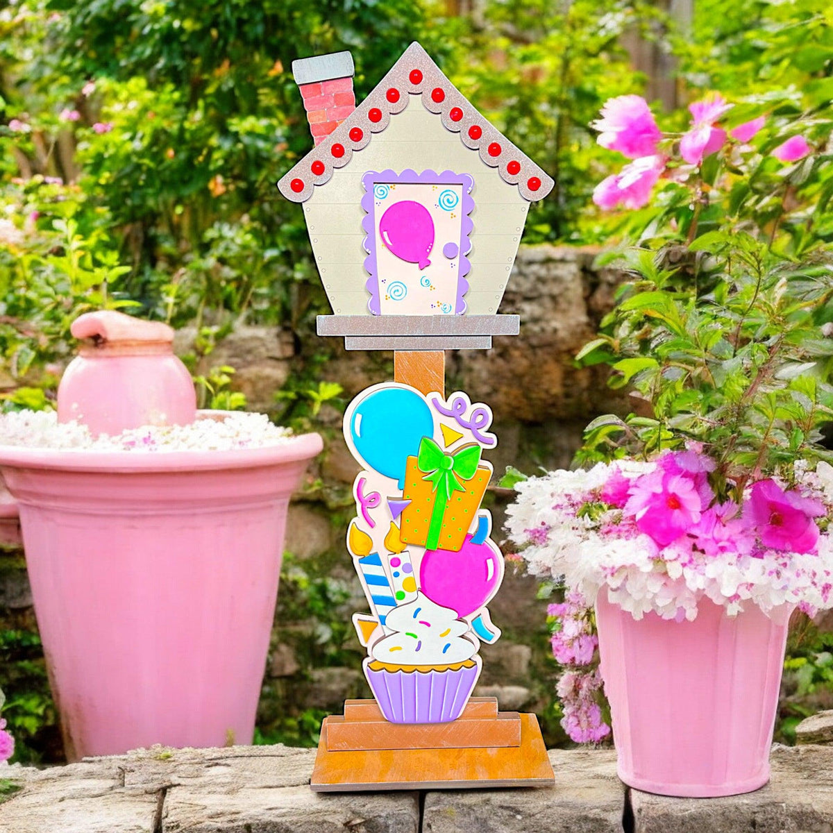 a pink potted plant with a house shaped decoration on top of it