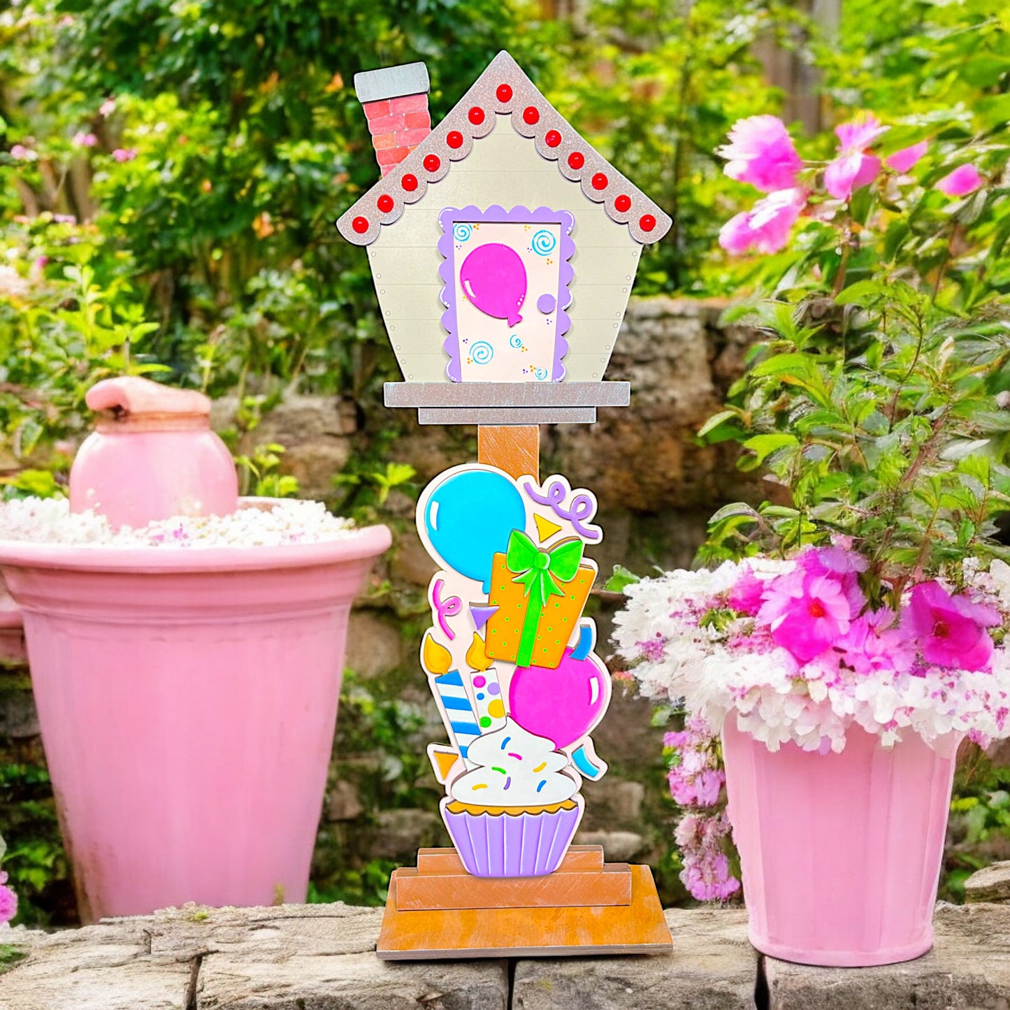 a pink potted plant with a house shaped decoration on top of it